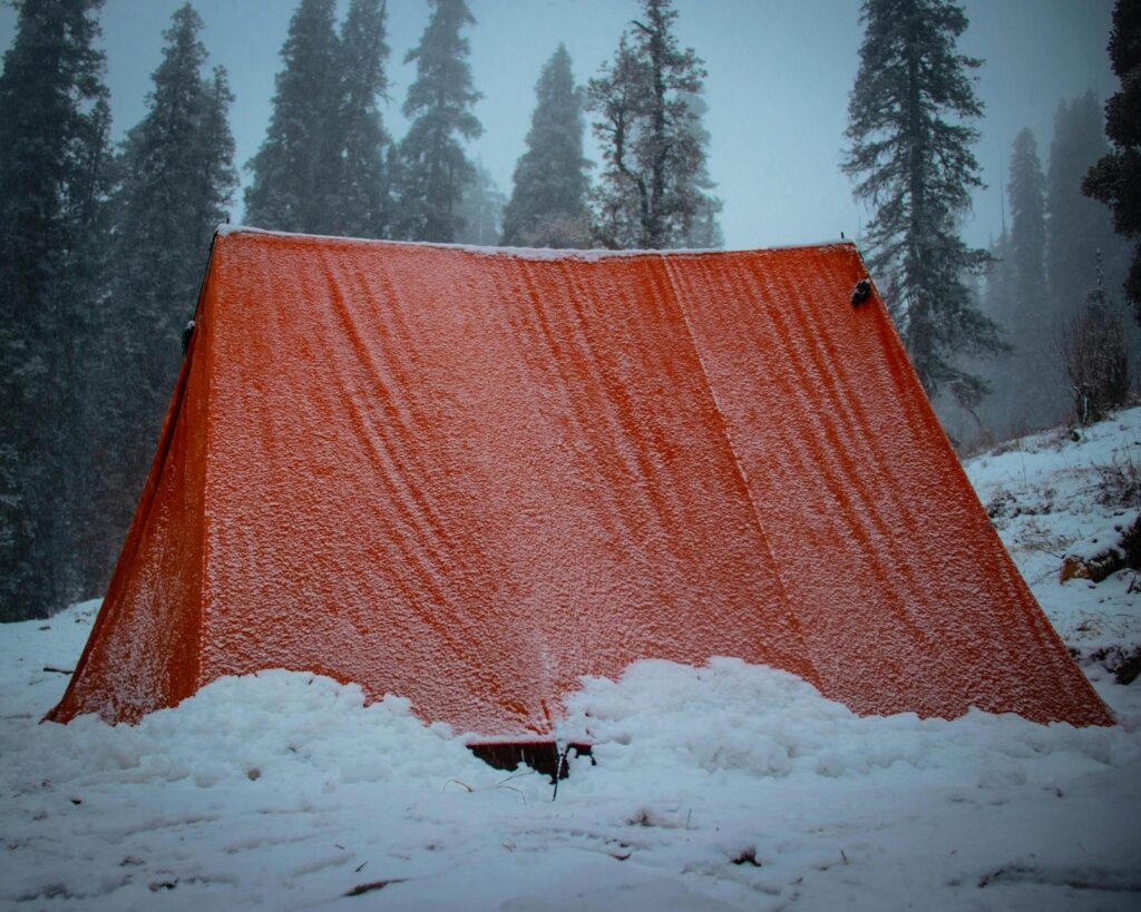 An ultralight camping tent pitched on a highly durable, waterproof HDPE tent footprint in the mountains